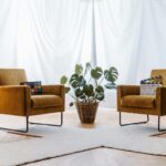 a living room with two chairs and a plant